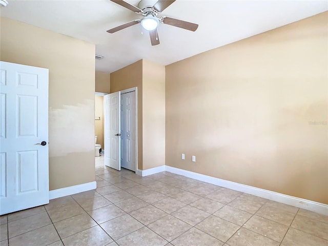 tiled spare room featuring ceiling fan