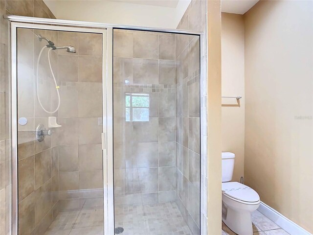 bathroom featuring toilet, an enclosed shower, and tile patterned floors