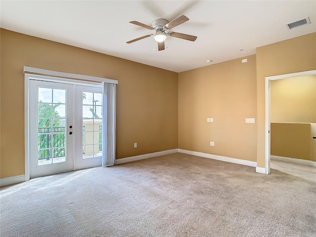 spare room featuring ceiling fan, light carpet, and french doors