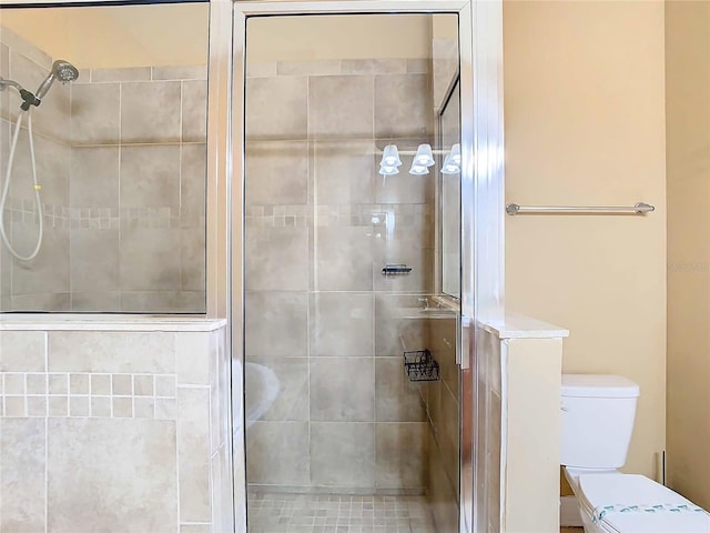 bathroom with toilet and a shower with shower door