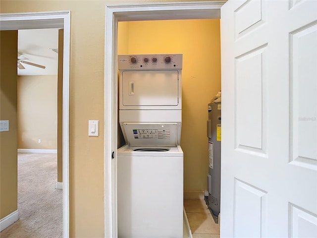 laundry room featuring water heater, light colored carpet, ceiling fan, and stacked washer and dryer