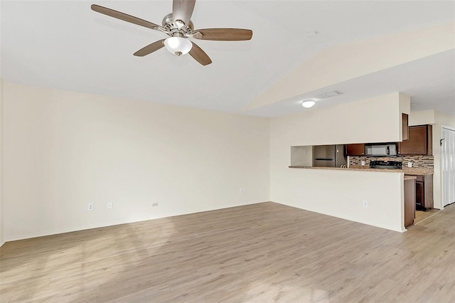 unfurnished living room with light hardwood / wood-style floors, vaulted ceiling, and ceiling fan