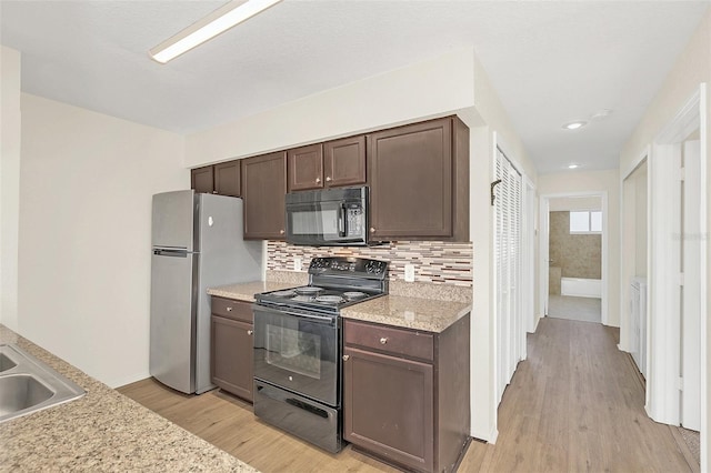 kitchen with black appliances, decorative backsplash, light hardwood / wood-style flooring, and dark brown cabinetry