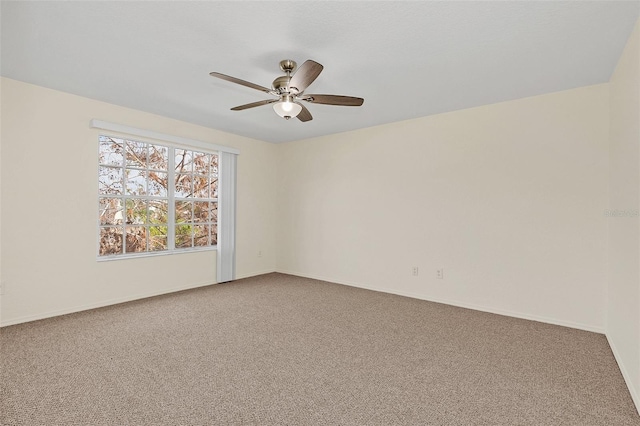 carpeted spare room featuring ceiling fan