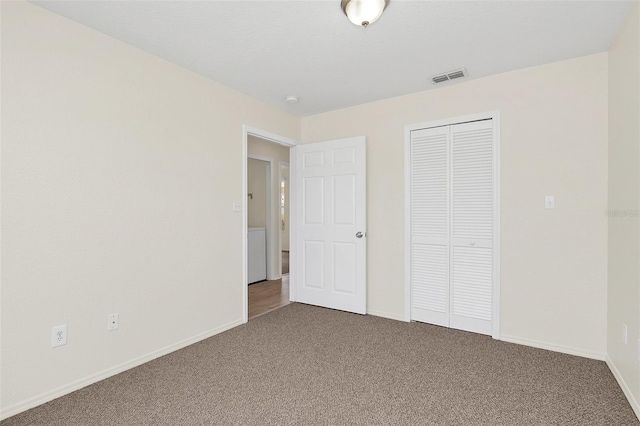 unfurnished bedroom with carpet floors and a closet