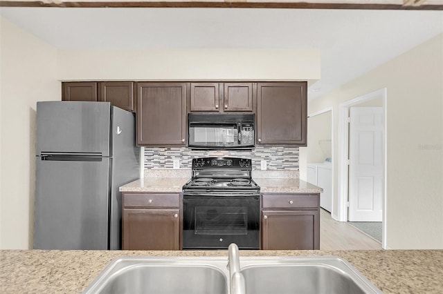 kitchen with backsplash, dark brown cabinetry, black appliances, and independent washer and dryer