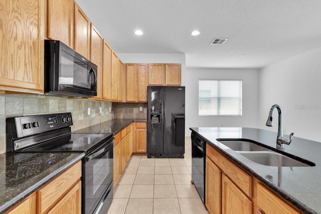 kitchen with light tile patterned flooring, sink, dark stone countertops, decorative backsplash, and black appliances