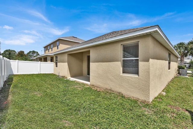 view of side of home with a yard and central AC unit