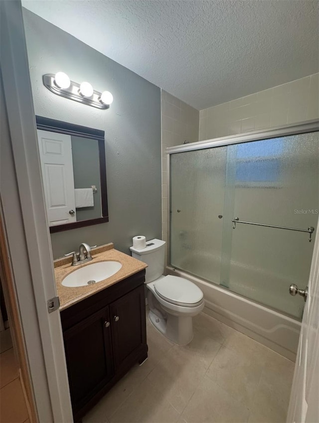 full bathroom with vanity, toilet, a textured ceiling, and shower / bath combination with glass door