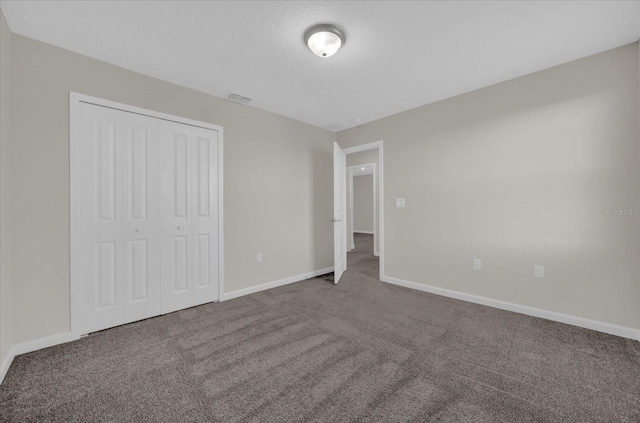 unfurnished bedroom with carpet floors and a closet