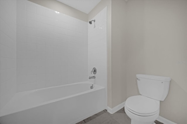 bathroom with toilet, tiled shower / bath, and tile patterned flooring