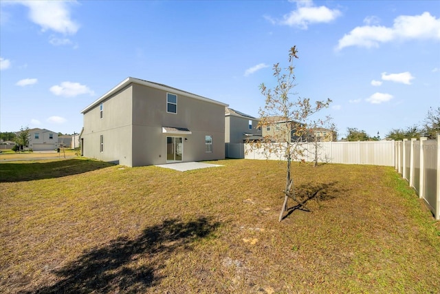 back of property featuring a lawn and a patio area