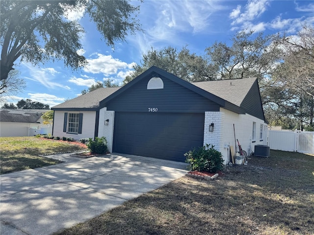 view of front of property featuring a garage and cooling unit