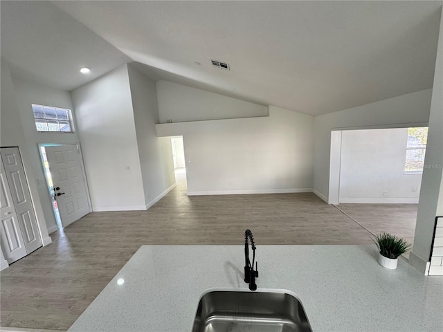 kitchen featuring hardwood / wood-style flooring, sink, and high vaulted ceiling