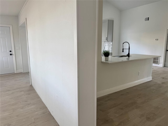 hallway featuring sink and light hardwood / wood-style flooring