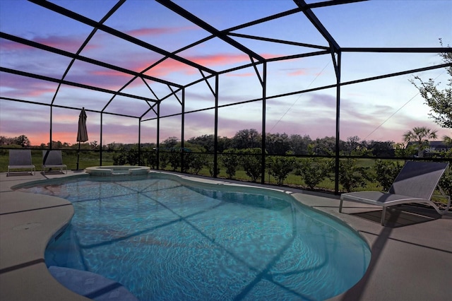 pool at dusk featuring an in ground hot tub, a lanai, and a patio