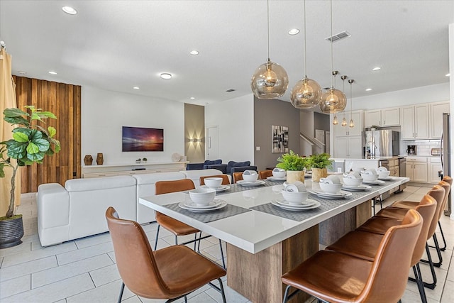 kitchen featuring light tile patterned floors, a kitchen bar, a center island, and hanging light fixtures