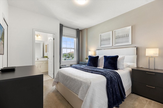 carpeted bedroom featuring ensuite bath