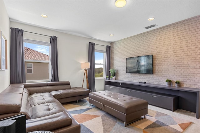 living room featuring brick wall and light carpet