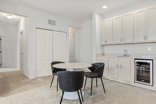 carpeted dining area featuring wet bar and wine cooler