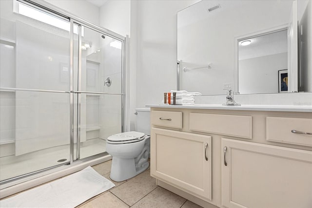 bathroom featuring vanity, toilet, tile patterned floors, and a shower with shower door