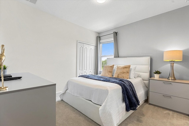 bedroom featuring light carpet and a closet