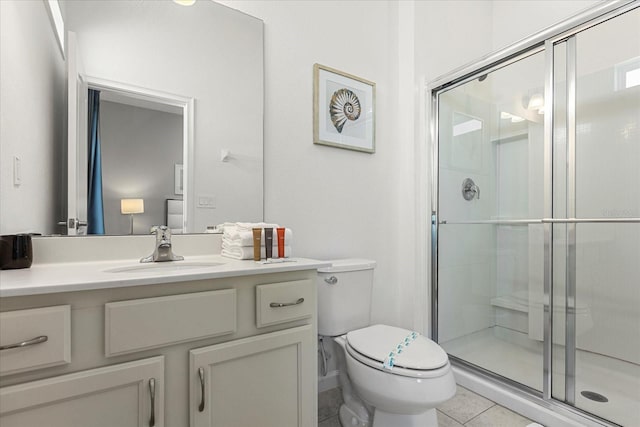 bathroom featuring vanity, toilet, tile patterned floors, and a shower with shower door