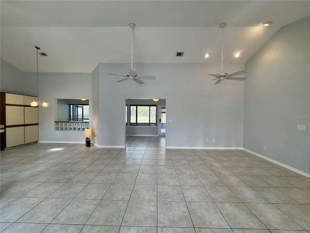 unfurnished living room with ceiling fan with notable chandelier, light tile patterned floors, and high vaulted ceiling