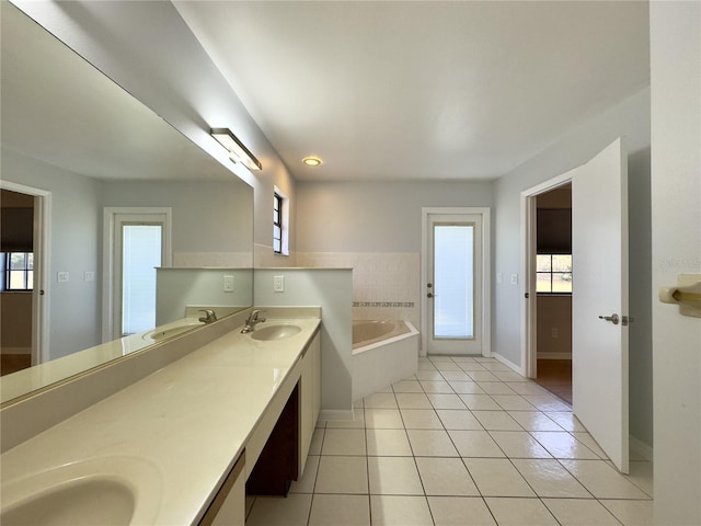 bathroom featuring a relaxing tiled tub, tile patterned floors, and vanity