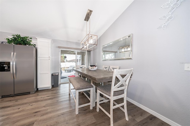 dining room with dark hardwood / wood-style flooring and vaulted ceiling