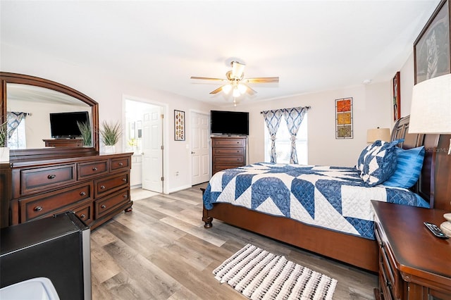 bedroom featuring light wood-type flooring, connected bathroom, and ceiling fan