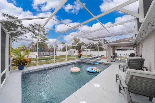 view of swimming pool featuring an in ground hot tub, a storage unit, a patio area, and glass enclosure