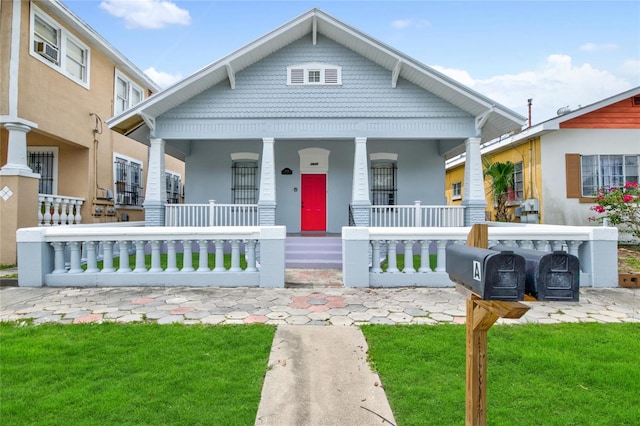 view of front of property with covered porch and a front yard