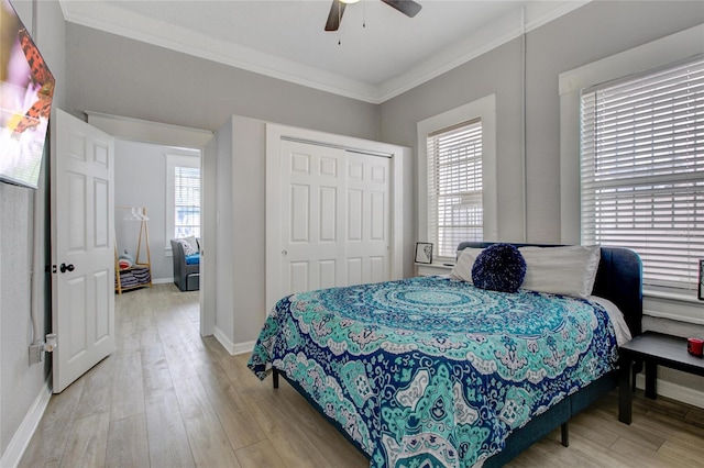 bedroom featuring a closet, ceiling fan, ornamental molding, and light hardwood / wood-style floors