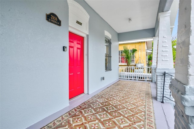 view of exterior entry featuring covered porch