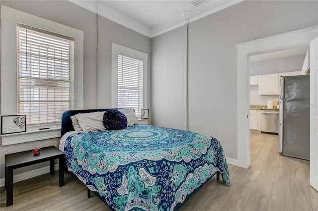 bedroom with crown molding, light wood-type flooring, stainless steel fridge, and ensuite bathroom