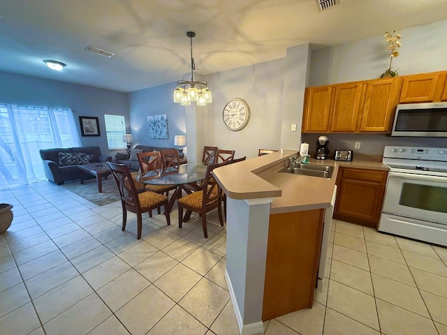 kitchen featuring sink, decorative light fixtures, light tile patterned floors, kitchen peninsula, and white range with electric stovetop