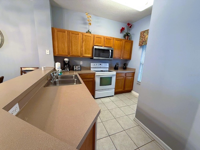 kitchen with sink, light tile patterned floors, a textured ceiling, and white range with electric cooktop