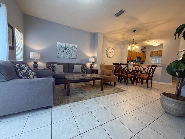 tiled living room featuring a chandelier