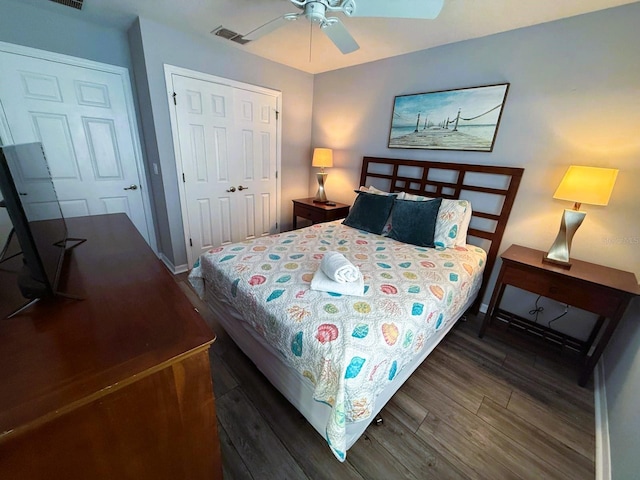 bedroom with dark wood-type flooring, ceiling fan, and a closet