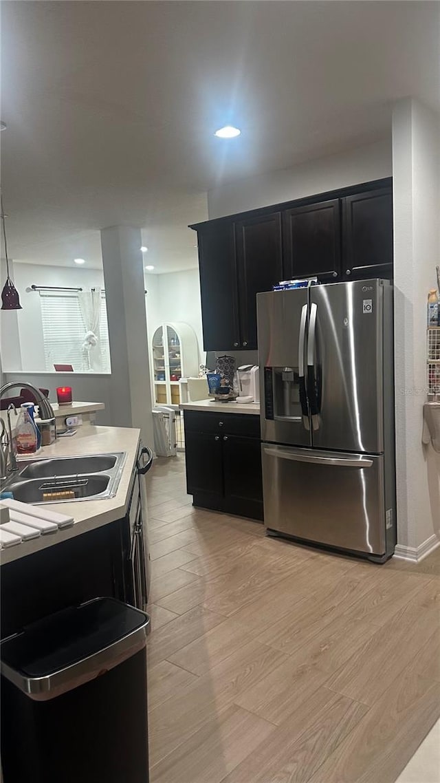 kitchen featuring stainless steel refrigerator with ice dispenser, sink, and light hardwood / wood-style floors