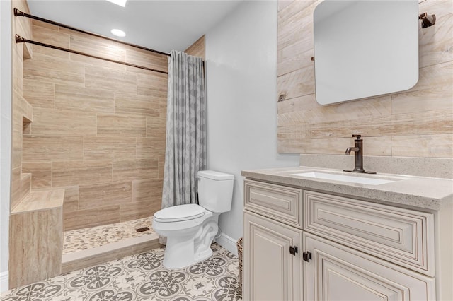 bathroom featuring tile patterned flooring, toilet, tiled shower, and vanity