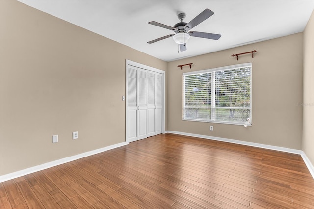 unfurnished bedroom with ceiling fan, hardwood / wood-style floors, and a closet