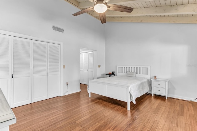 unfurnished bedroom with beamed ceiling, wood ceiling, light wood-type flooring, high vaulted ceiling, and ceiling fan