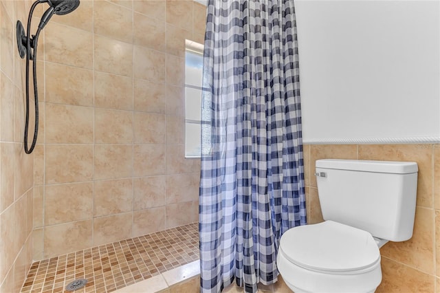 bathroom with tile walls, toilet, and a shower with shower curtain