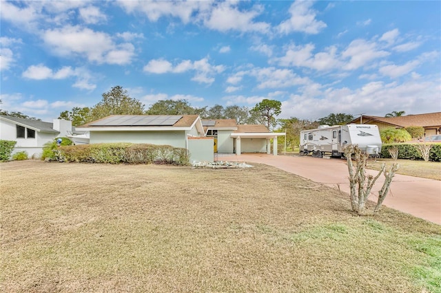 ranch-style house with solar panels and a front yard