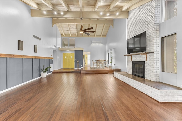 interior space featuring track lighting, a towering ceiling, and a fireplace