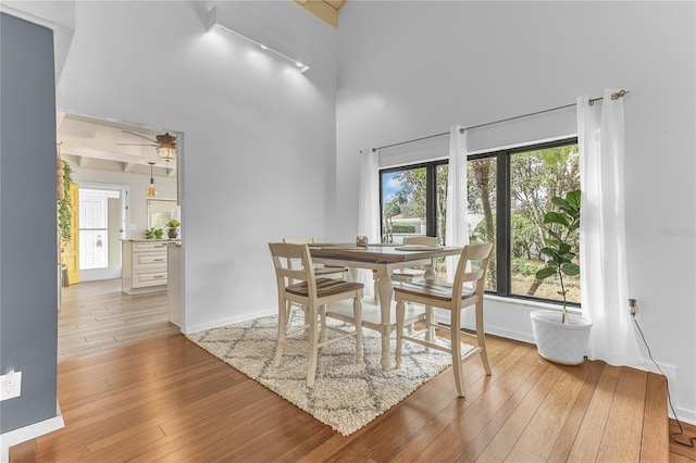 dining area featuring a high ceiling and light hardwood / wood-style flooring