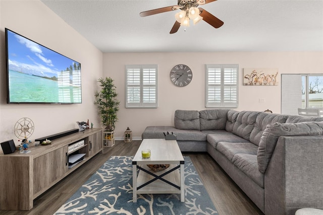 living room with a healthy amount of sunlight, a textured ceiling, dark hardwood / wood-style floors, and ceiling fan