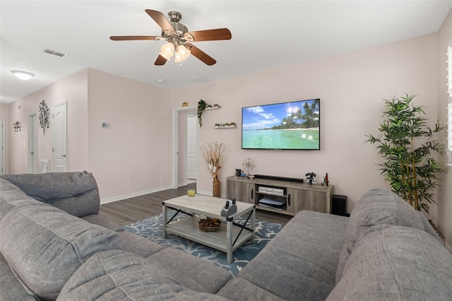 living room featuring dark wood-type flooring and ceiling fan